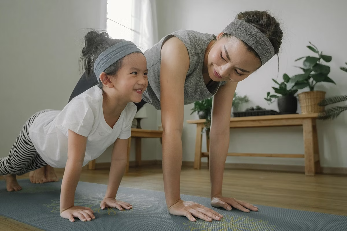 Mamá e hija practicando Yoga para estimular el cuerpo y mejorar la salud. 